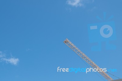 Yellow High Long Crane Arrow At Construction Site With Clear Light Blue Sky Day Stock Photo