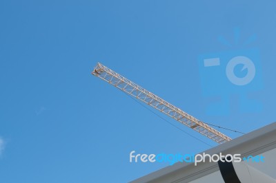 Yellow High Long Crane Arrow At Construction Site With Clear Light Blue Sky Day Stock Photo