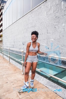 Young African Woman Riding On Skates Stock Photo