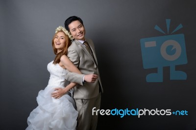 Young Asian Groom And Bride Posing And Smiling In Studio For Pre… Stock Photo