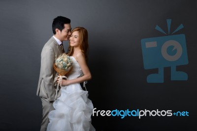 Young Asian Groom And Bride Posing And Smiling In Studio For Pre… Stock Photo