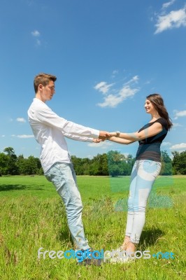 Young Attractive Couple Holding Each Other In Sunny Meadow Stock Photo