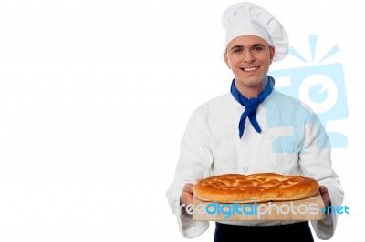 Young Baker Holds A Loaf On Breadboard Stock Photo