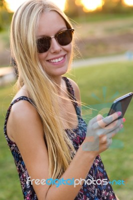 Young Beautiful Girl Texting With Her Phone Stock Photo