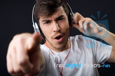 Young Beautiful Man Listening To Music. Isolated On Black Stock Photo