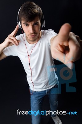 Young Beautiful Man Listening To Music. Isolated On Black Stock Photo