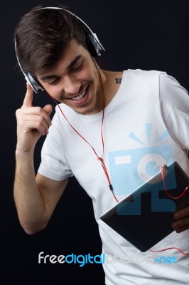 Young Beautiful Man Listening To Music. Isolated On Black Stock Photo