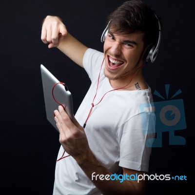 Young Beautiful Man Listening To Music. Isolated On Black Stock Photo