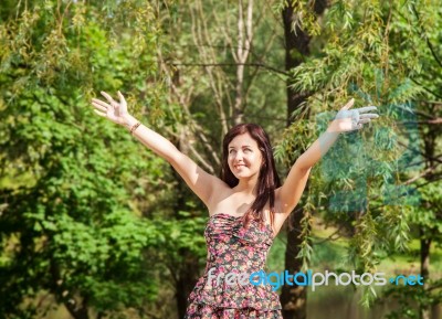 Young Beautiful Smiling Girl Holds Out Her Hands To The Sky Stock Photo