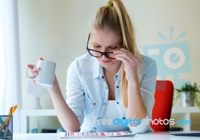 Young Beautiful Woman Holding A Cup Of Coffee And Reading Newspa… Stock Photo