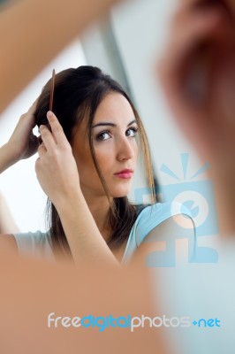 Young Beautiful Woman Making Hairstyle Near Mirror Stock Photo