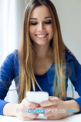 Young Beautiful Woman Using Her Mobile Phone At Home Stock Photo