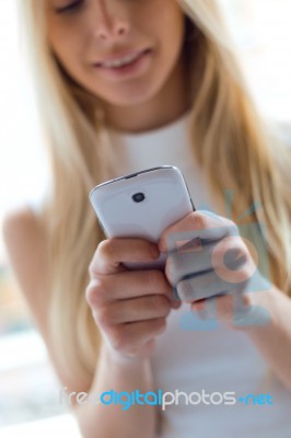 Young Beautiful Woman Using Her Mobile Phone At Home Stock Photo