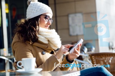 Young Beautiful Woman Using Her Mobile Phone In A Cafe Stock Photo