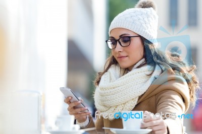 Young Beautiful Woman Using Her Mobile Phone In A Cafe Stock Photo