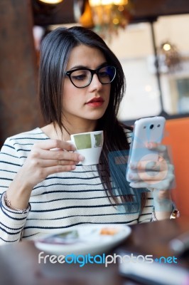 Young Beautiful Woman Using Her Mobile Phone In Coffee Stock Photo