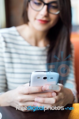 Young Beautiful Woman Using Her Mobile Phone In Coffee Stock Photo