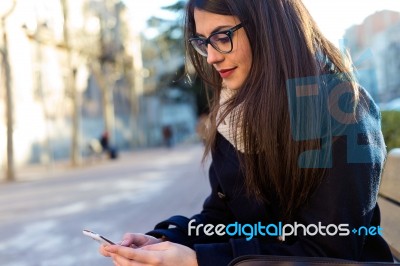 Young Beautiful Woman Using Her Mobile Phone In The Street Stock Photo