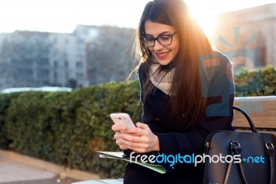 Young Beautiful Woman Using Her Mobile Phone In The Street Stock Photo