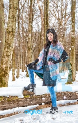 Young Beautiful Woman Walking Under A Snowfall Stock Photo