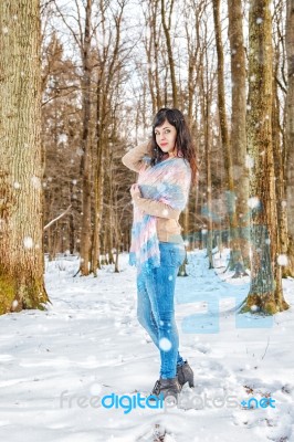 Young Beautiful Woman Walking Under A Snowfall Stock Photo