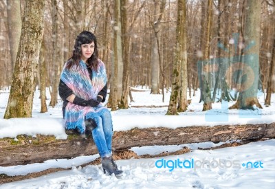 Young Beautiful Woman Walking Under A Snowfall Stock Photo