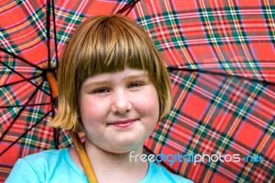 Young Blonde Girl Under Umbrella In Rain Stock Photo