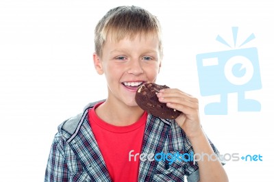 Young Boy Eating Chocolate Cookie Stock Photo