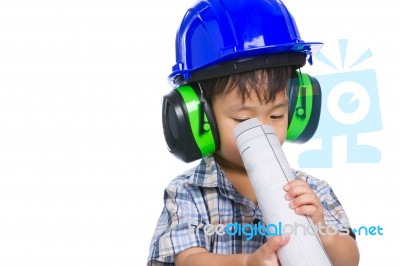 Young Boy Engineer With Blueprint, Wearing Earmuffs And Blue Helmet Stock Photo