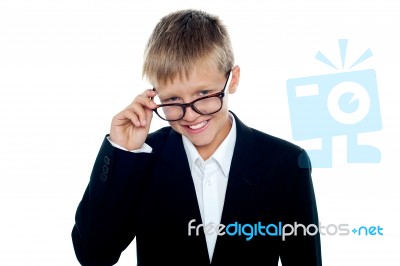 Young Boy Removing Eyeglass Stock Photo