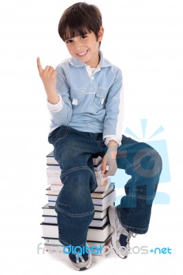 Young Boy Sitting Over Tower Of Books Stock Photo