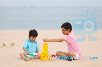 Young Brothers Play On Beach Stock Photo