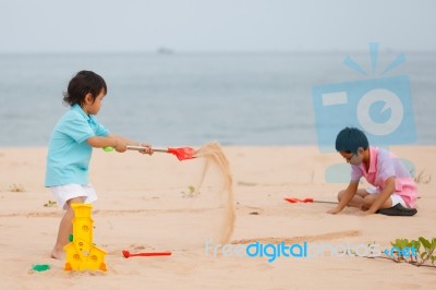 Young Brothers Play On Beach Stock Photo