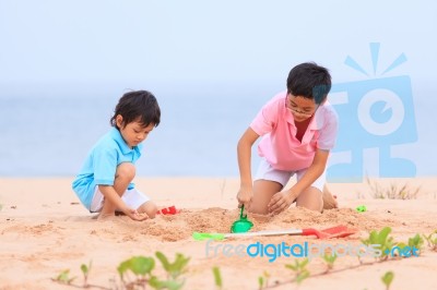 Young Brothers Play On Beach Stock Photo