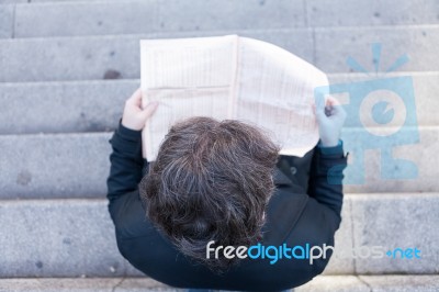 Young Business Man Reading A Newspaper Viewed From Above Stock Photo