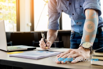 Young Business Man Working In Bright Office, Using Laptop, Writi… Stock Photo