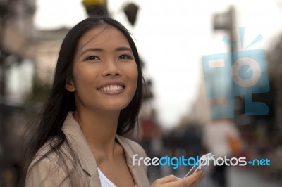 Young Business Women With Cell Phone Looking At Someone Stock Photo