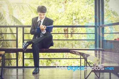 Young Businessman Looking At Report Paper Stock Photo