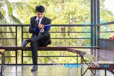 Young Businessman Looking At Report Paper Stock Photo