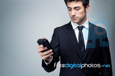 Young Businessman Looking At Smartphone Stock Photo