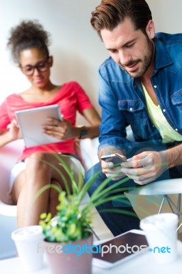 Young Businessman Using The Mobile Phone And Business Woman Usin… Stock Photo