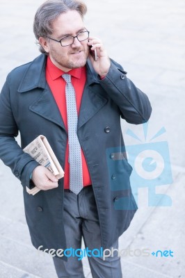 Young Businessman With A Newspaper With An Smartphone Stock Photo