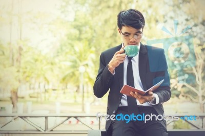 Young Businessmen Are Looking At Report Paper And Holding A Cup Stock Photo