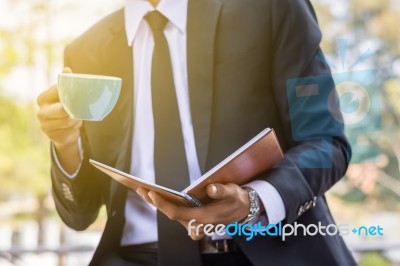 Young Businessmen Are Looking At Report Paper And Holding A Cup Stock Photo