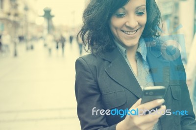 Young Businesswoman With Smartphone Walking On City Stock Photo