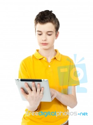 Young Caucasian Kid Working On Tablet Pc Stock Photo