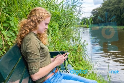 Young Caucasian Woman Operates Mobile Phone Stock Photo