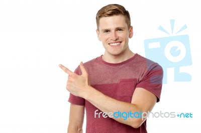 Young Cheerful Man Pointing Away Stock Photo