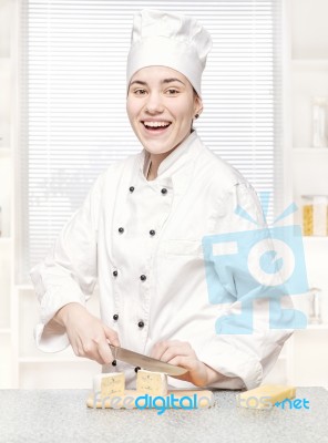 Young Chef Cutting Blue Cheese In Kitchenn Stock Photo