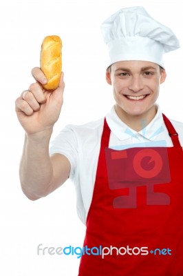 Young Chef Holding Bread Roll Stock Photo